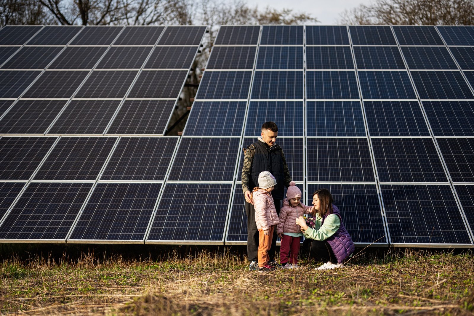 Family with two daughters on the background of solar panels. Ec
