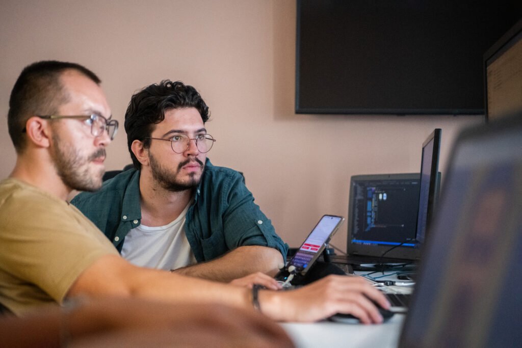 Programmers engrossed in deep collaboration, diligently working together to solve complex problems and develop innovative mobile applications with seamless functionality.